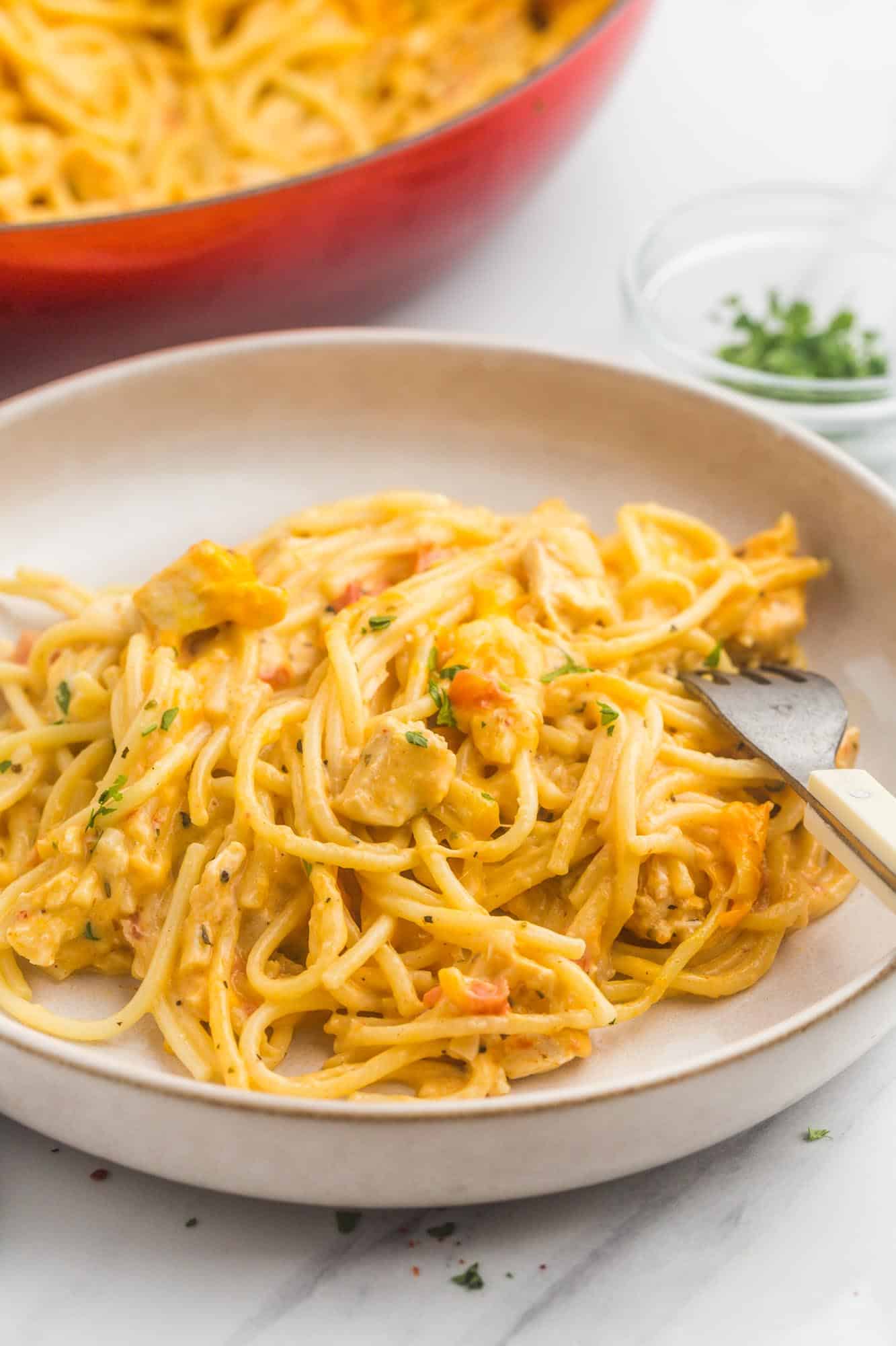 a deep pasta bowl with a serving of chicken spaghetti casserole.