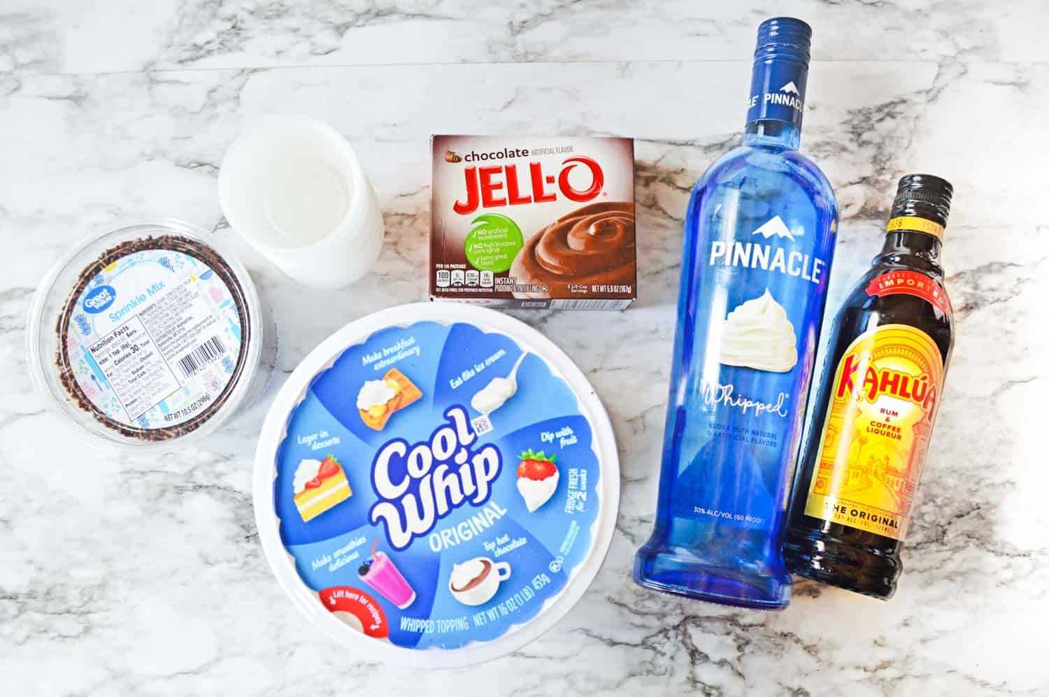 The ingredients for chocolate pudding shots, set on a marble counter and viewed from above