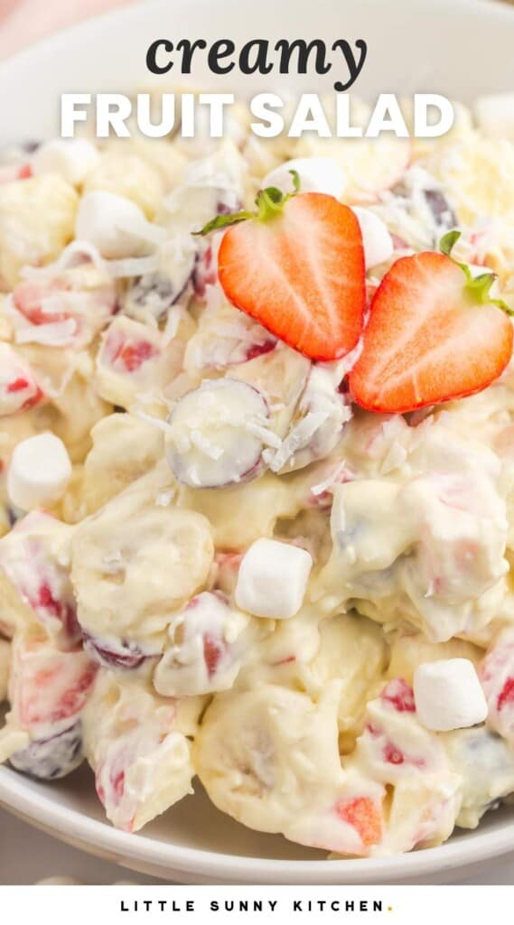 close up view of fruit salad with whipped cream. Text at top of image reads Creamy Fruit Salad