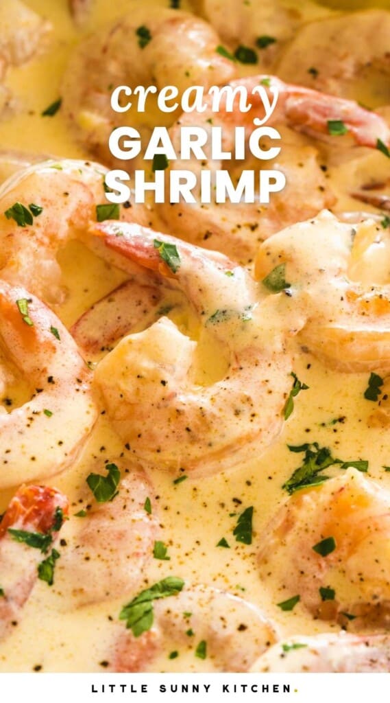 Cooked shrimp in a creamy sauce, garnished with black pepper and parsley, closeup. Text overlay says Creamy Garlic Shrimp