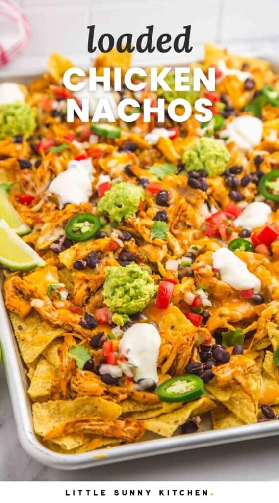 a large tray of nachos topped with chicken, guacamole, sour cream, and jalapenos. Text at top of image reads "Loaded chicken Nachos"