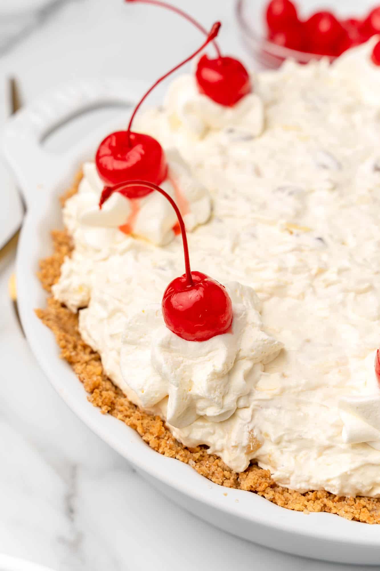 closeup of the edge of million dollar pie decorated with whipped cream and cherries