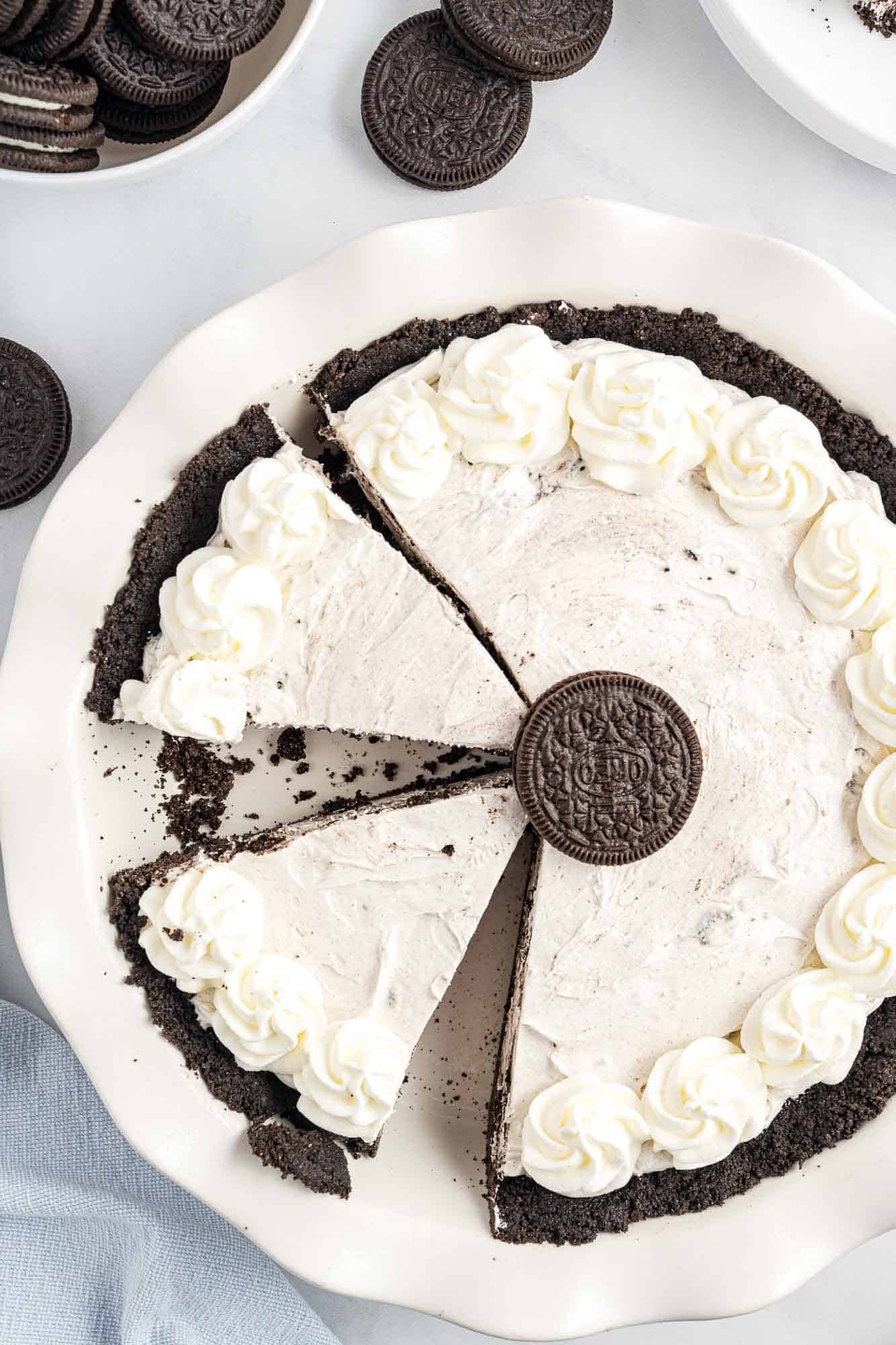 an oreo pie that's been sliced. One slice is missing from the left side. Viewed from above