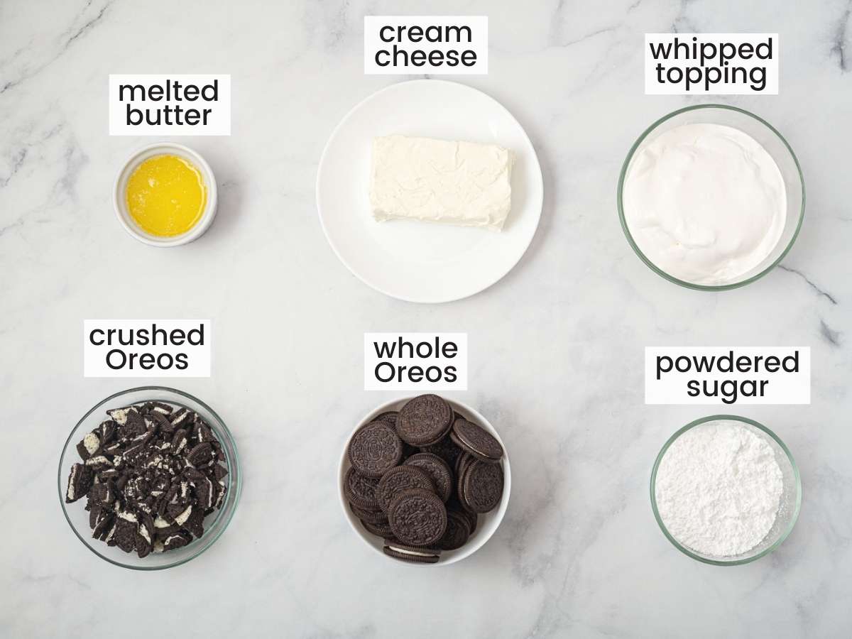 The six ingredients needed to make oreo pie, measured into bowls and lined up in two rows on a counter. Text overlay labels each ingredient. 