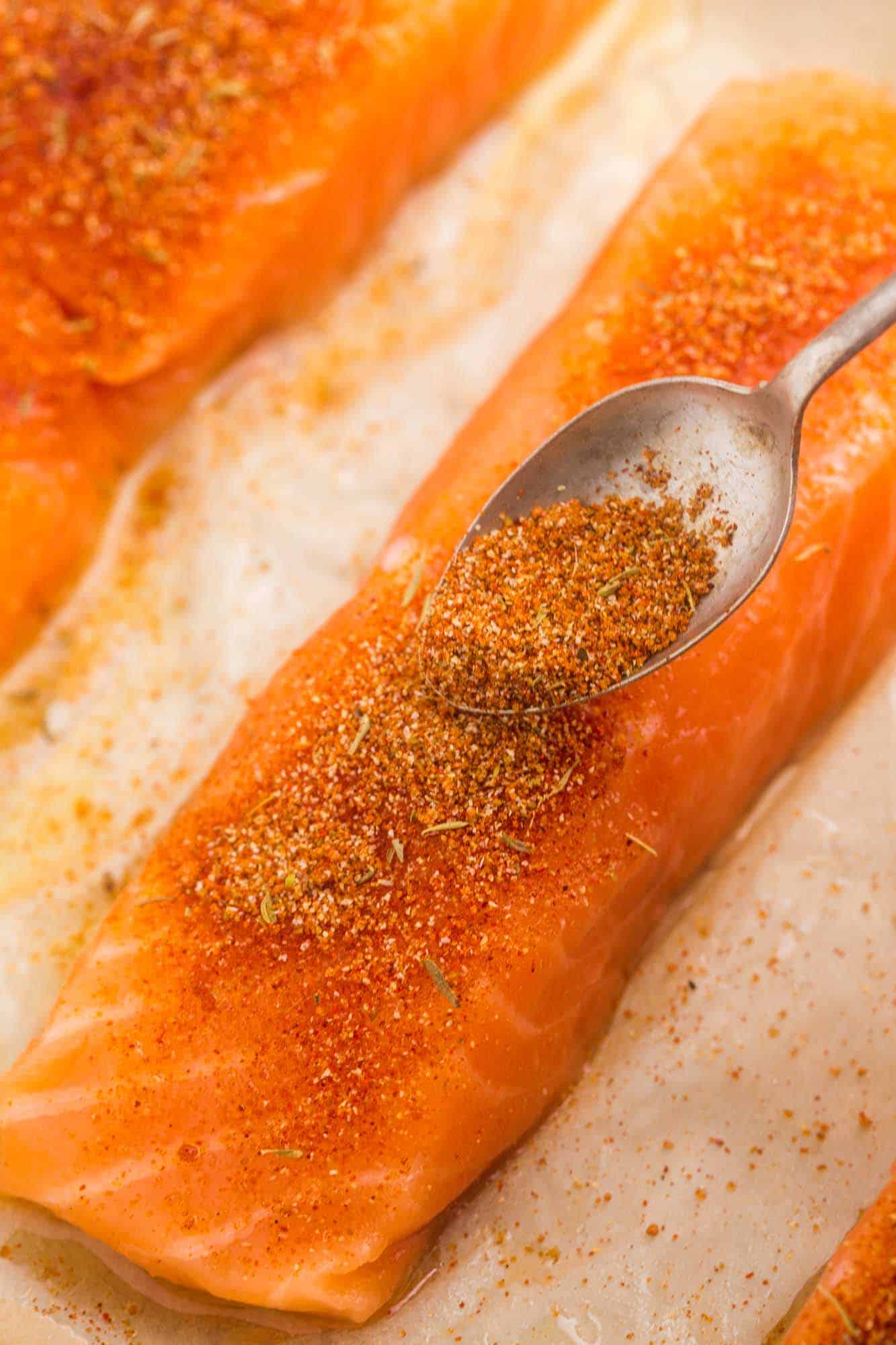 Sprinkling seasoning over salmon fillet