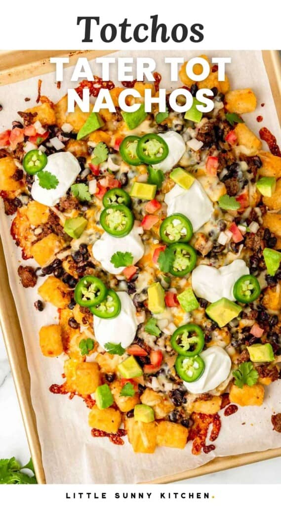 Tater tot nachos topped with jalapeno slices, avocado, sour cream and diced tomato. With overlay text that says "totchos, tater tot nachos"