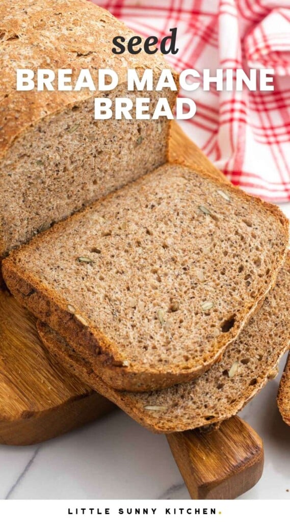 Sliced seed bread on a wooden cutting board. And overlay text that says "seed bread machine bread"