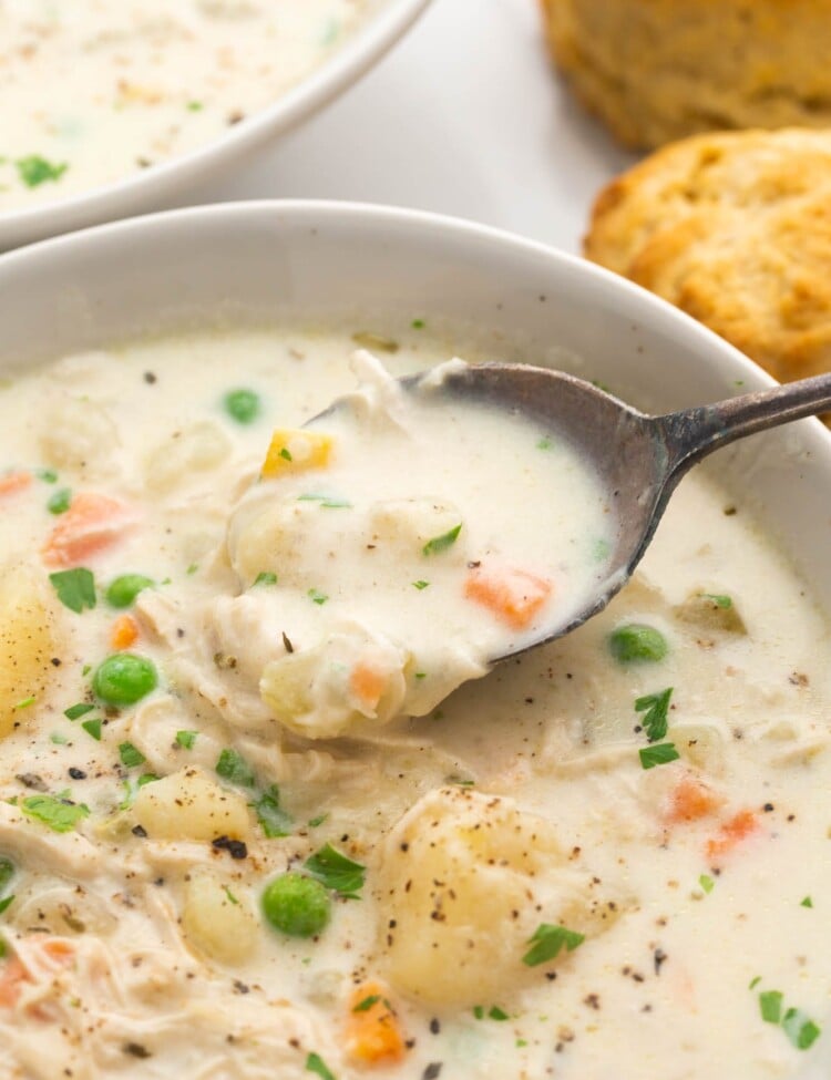Close up shot of chicken pot pie soup in a bowl with a spoon