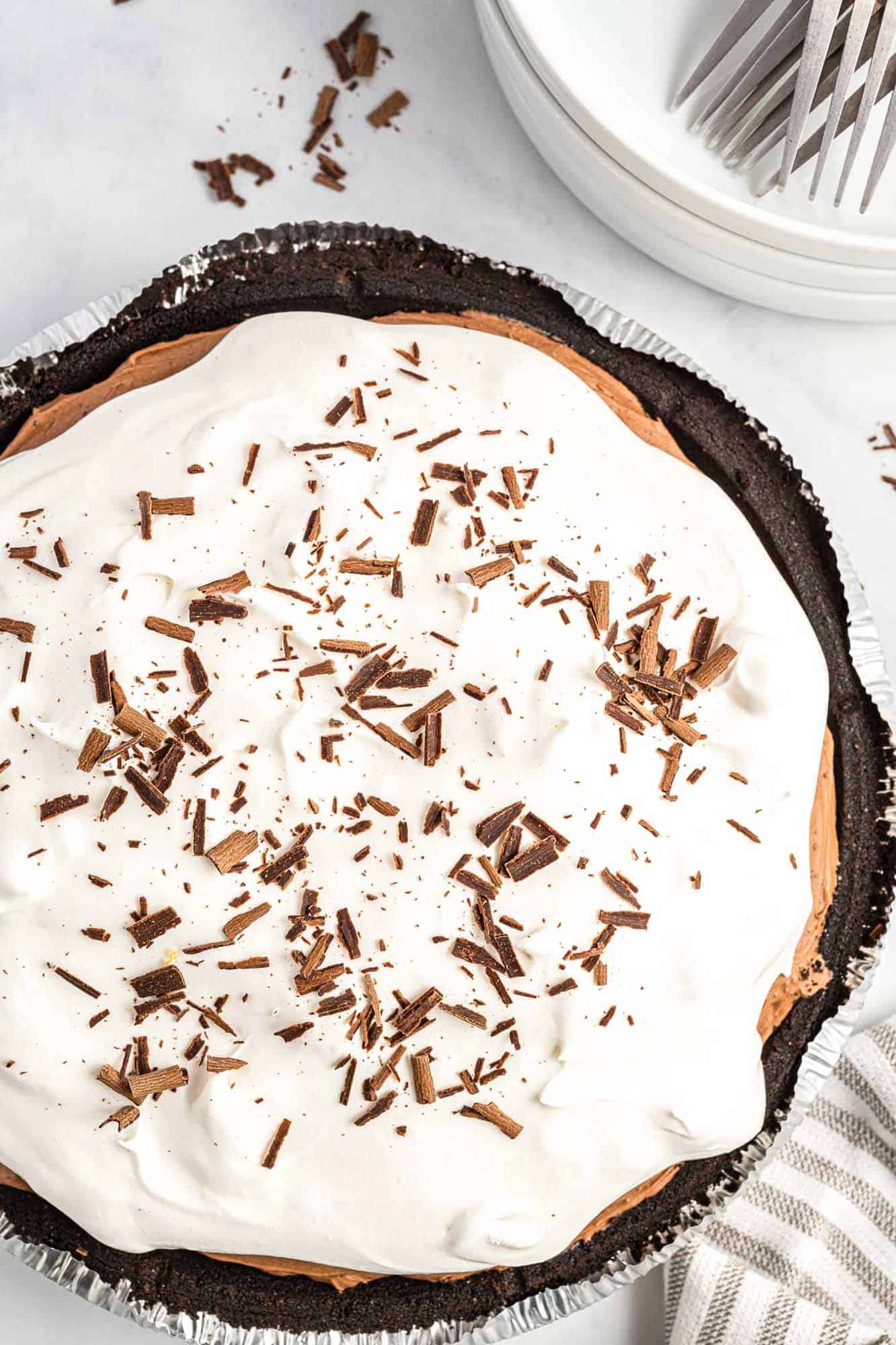 a chocolate pudding pie with whipped topping and chocolate shavings, viewed from above.