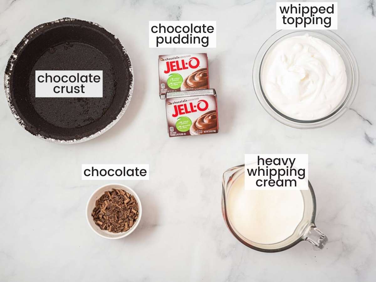 The ingredients needed to make jello pudding pie, all in separate bowls on a counter. Includes a premade chocolate crust and boxed jello pudding