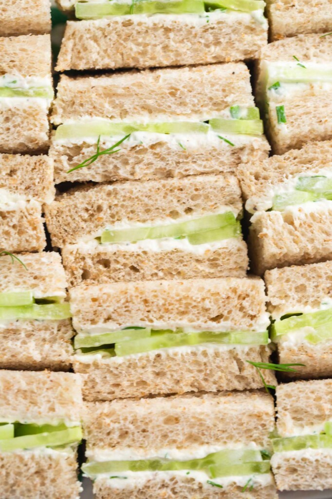cucumber tea sandwiches, set up on their edges, lined up, viewed from close up.