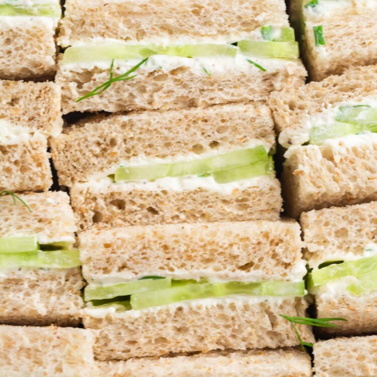 cucumber tea sandwiches, set up on their edges, lined up, viewed from close up.