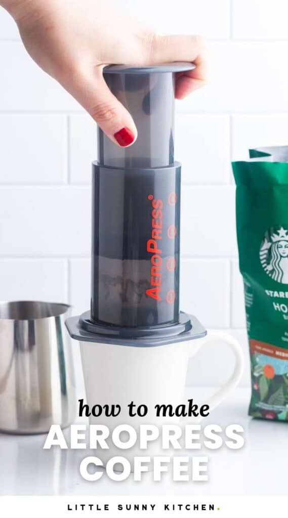 a female hand with red nails, using an aeropress to make a cup of coffee.