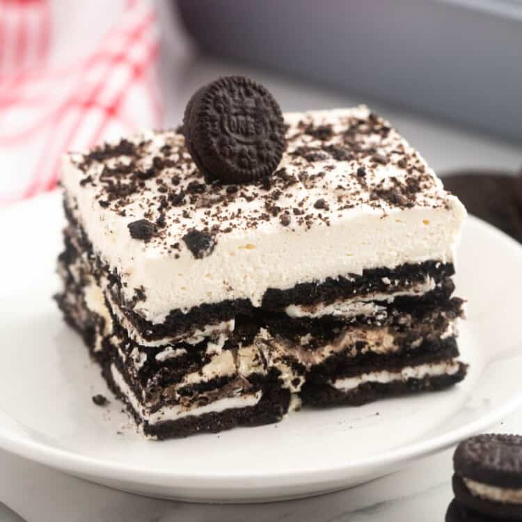 a square piece of layered oreo icebox cake with a miniature oreo on top.