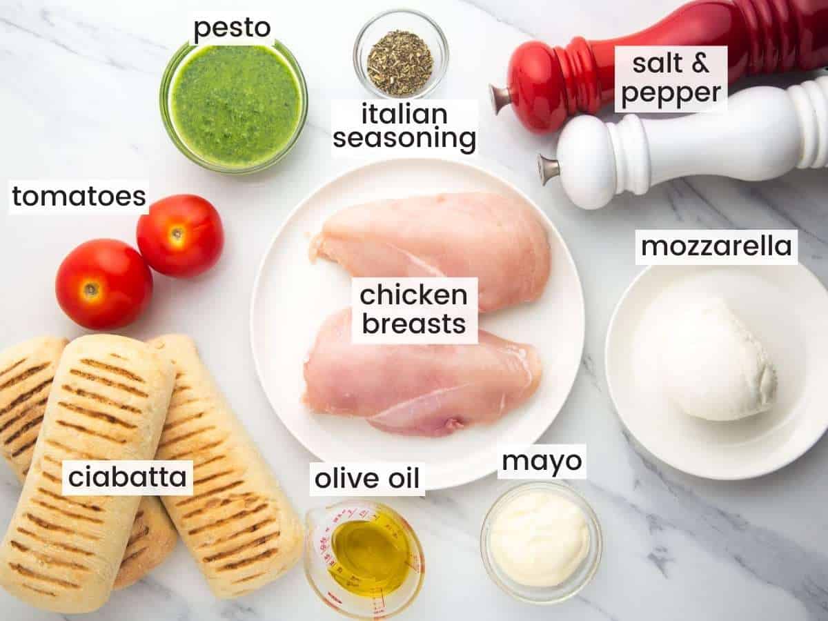 The ingredients needed to make a chicken pesto sandwich with mozzarella and tomatoes