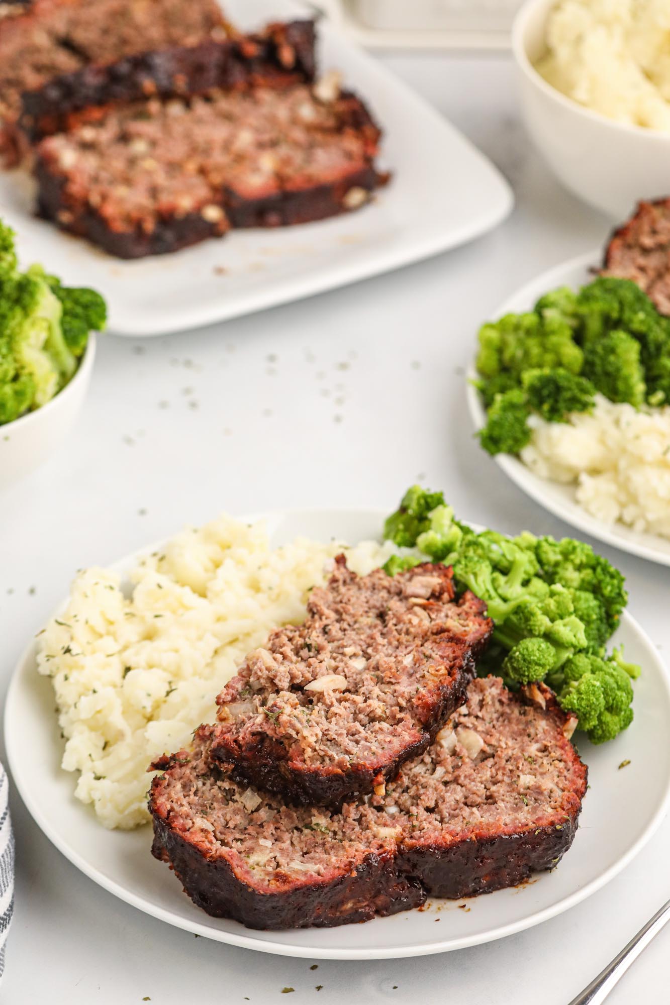 2 portions of BBQ glazed smoked meatloaf, with mashed potatoes, and broccoli on the side.