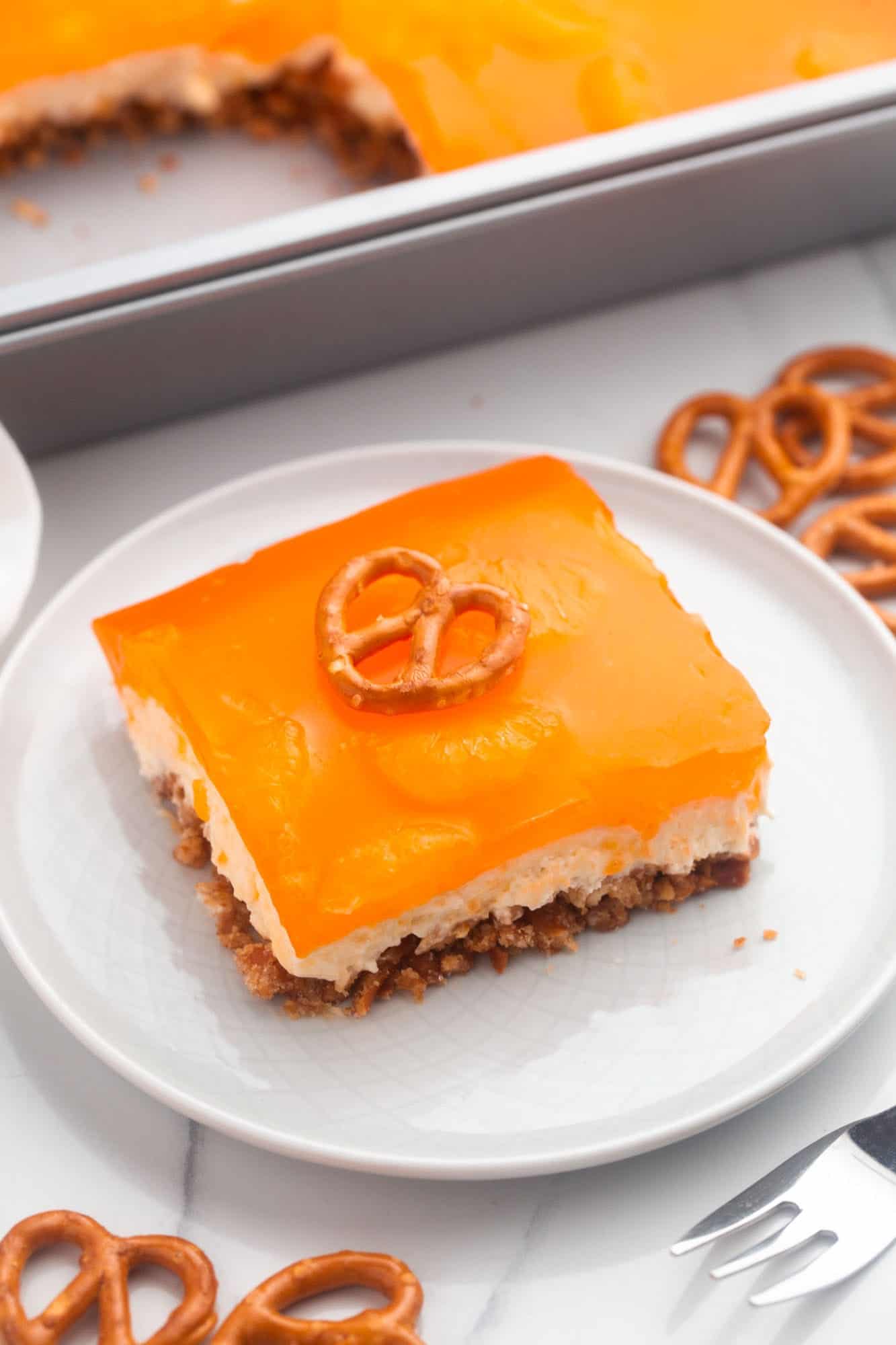 an orange pretzel salad square on an small white plate