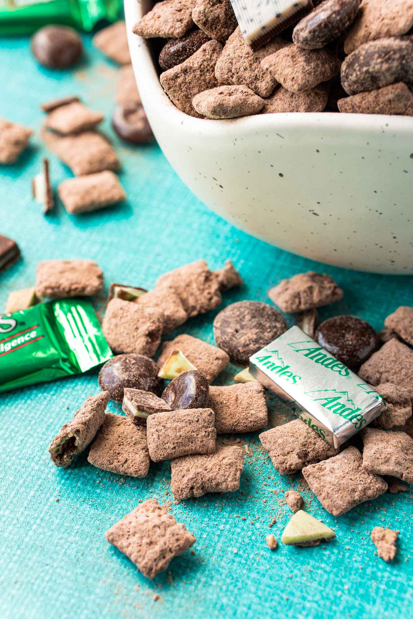 A handful of mint chocolate puppy chow on the table with andes mints mixed in. 