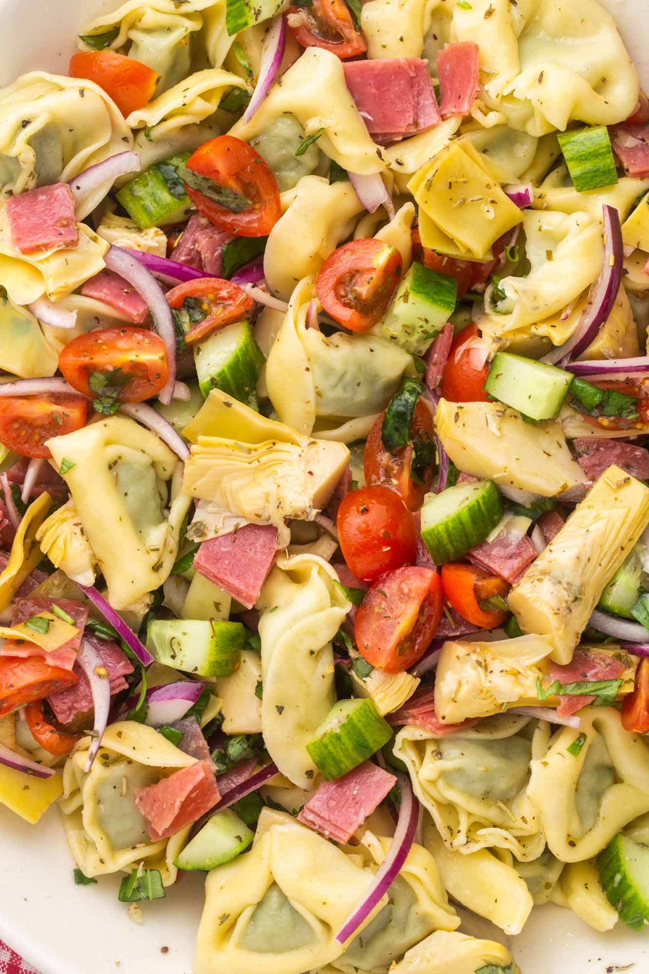 closeup of tortellini salad with artichokes and tomatoes