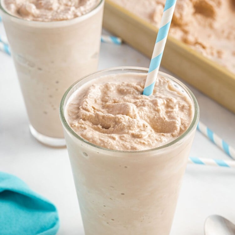 two glasses of chocolate wendy's frosty with paper straws