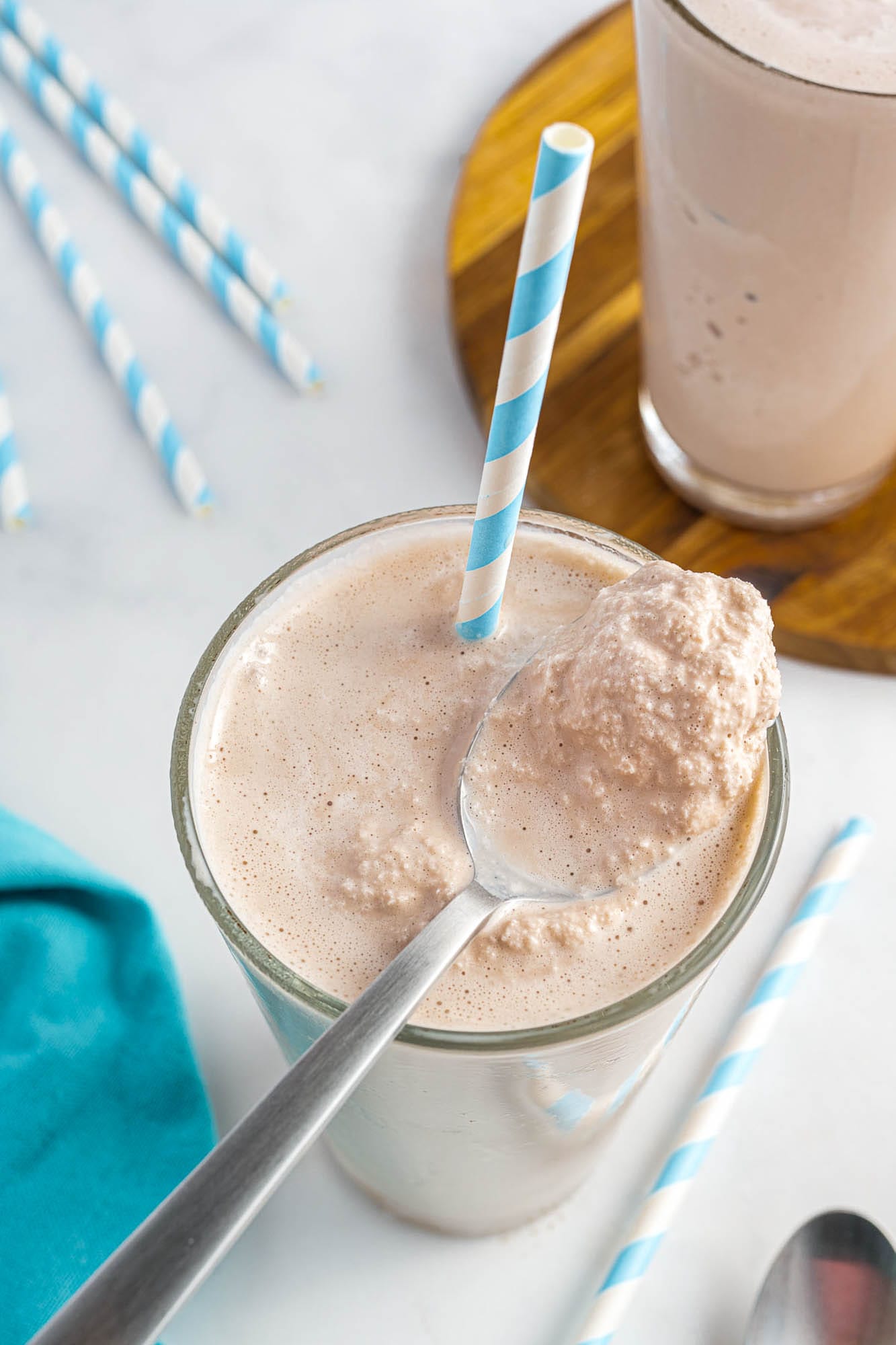 a homemade wendys frosty with a paper stray and a spoon in it. 