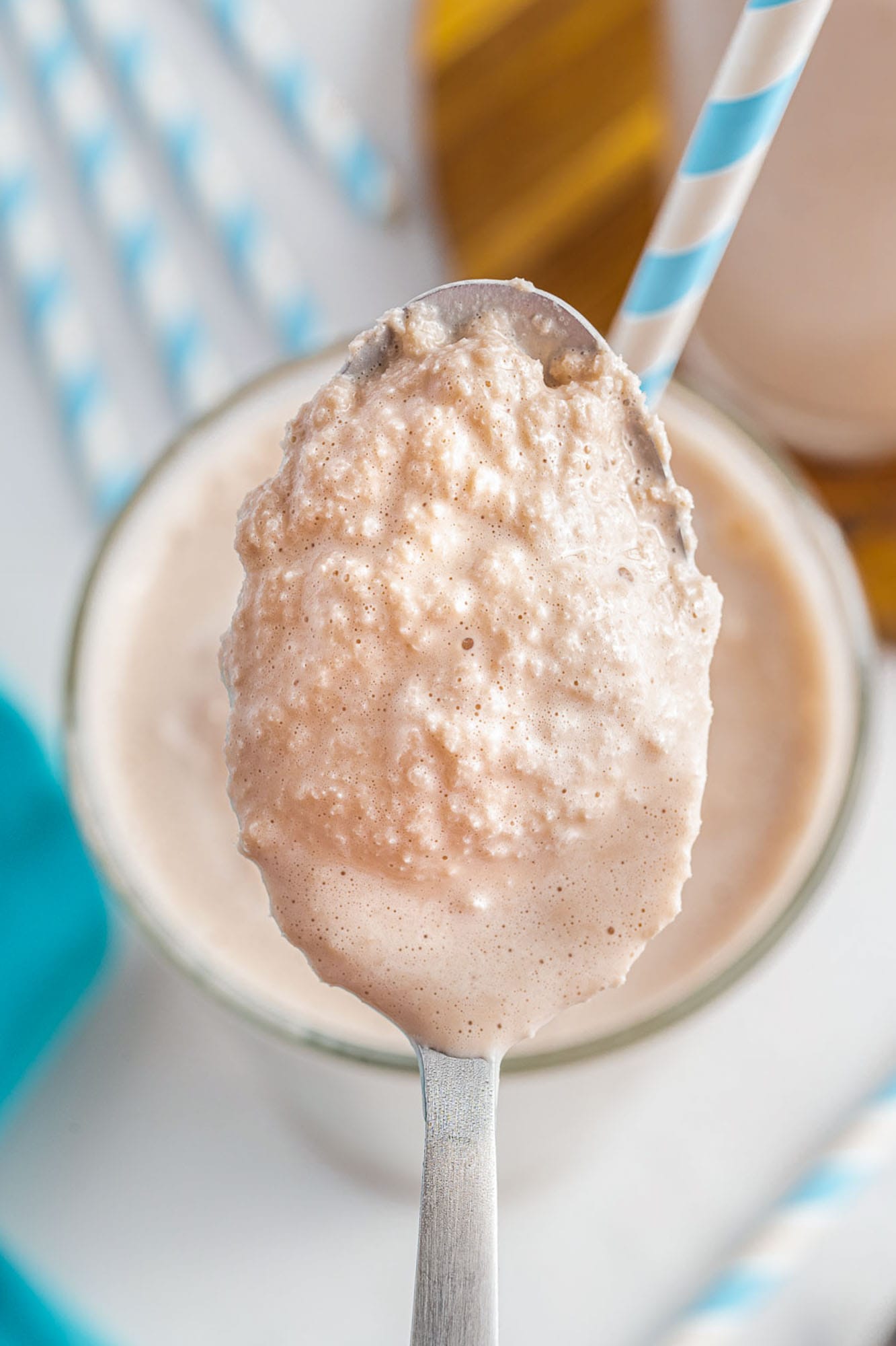 a spoon holding up a scoop of copycat frosty to show the slushy creamy texture