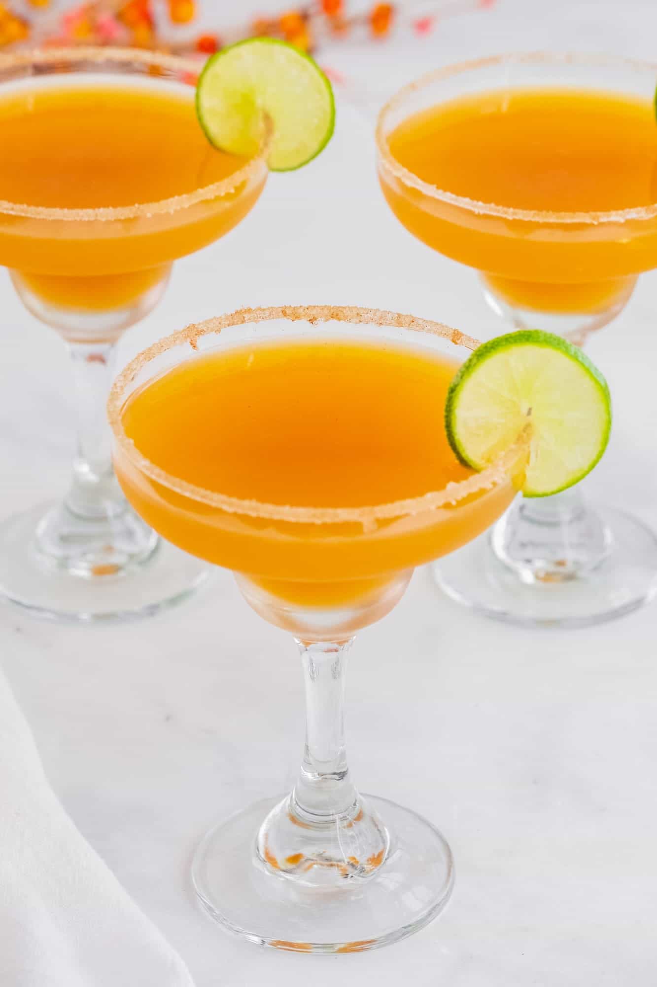three apple cider margaritas with sugar rims, viewed from overhead