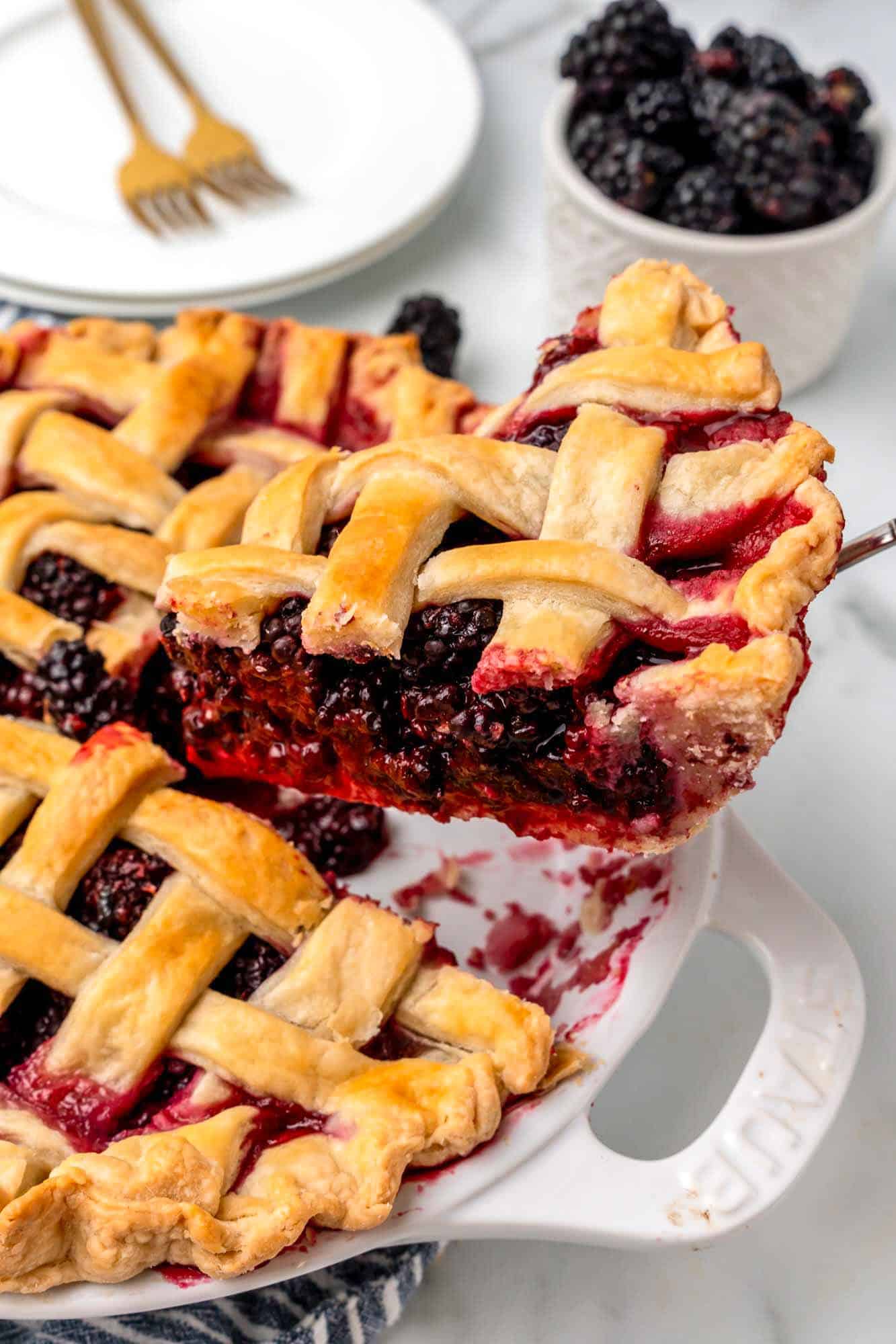 a slice of blackberry pie being lifted out of the pan. 