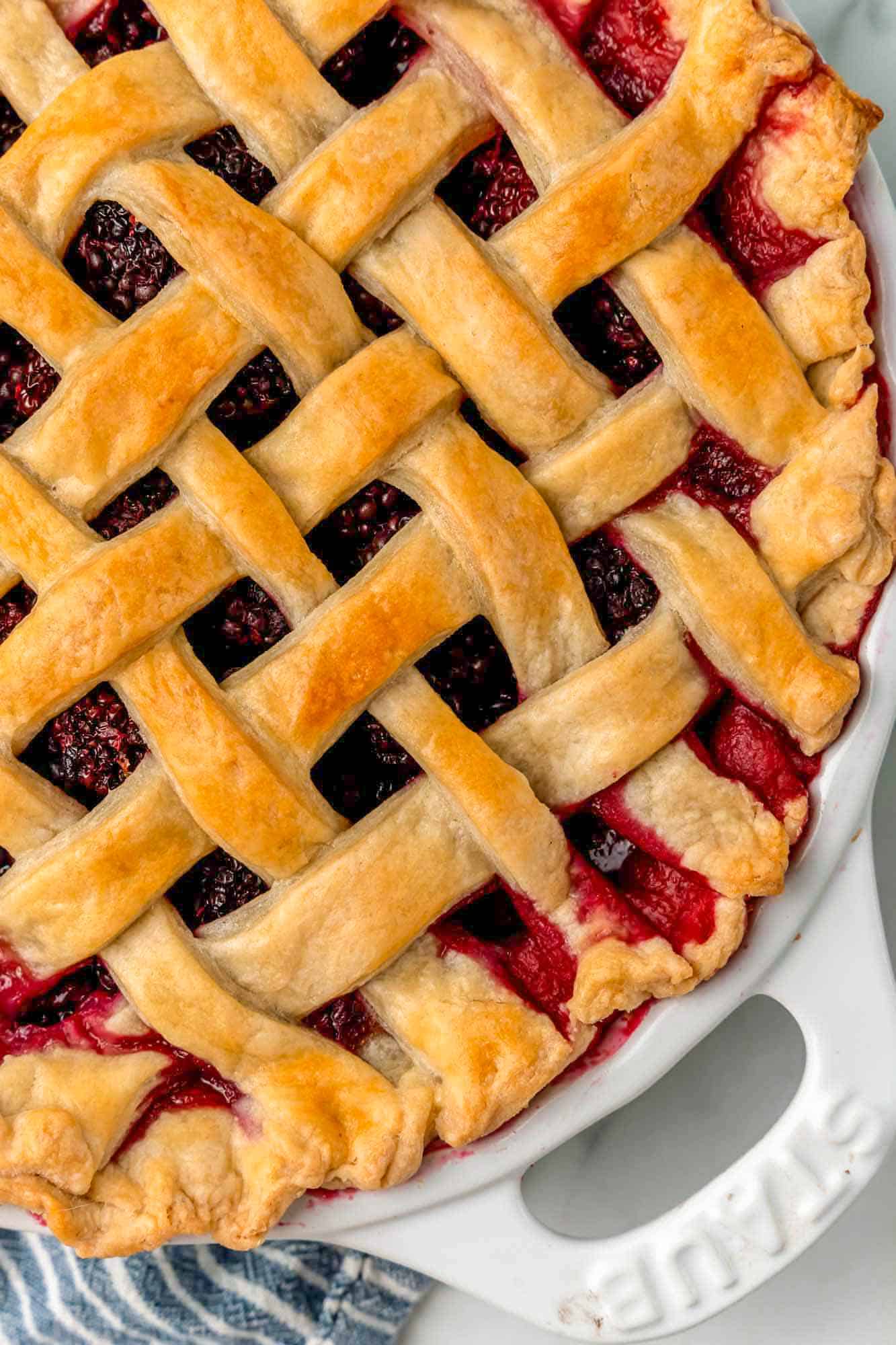 cropped image of half of a lattice top blackberry pie, viewed from above