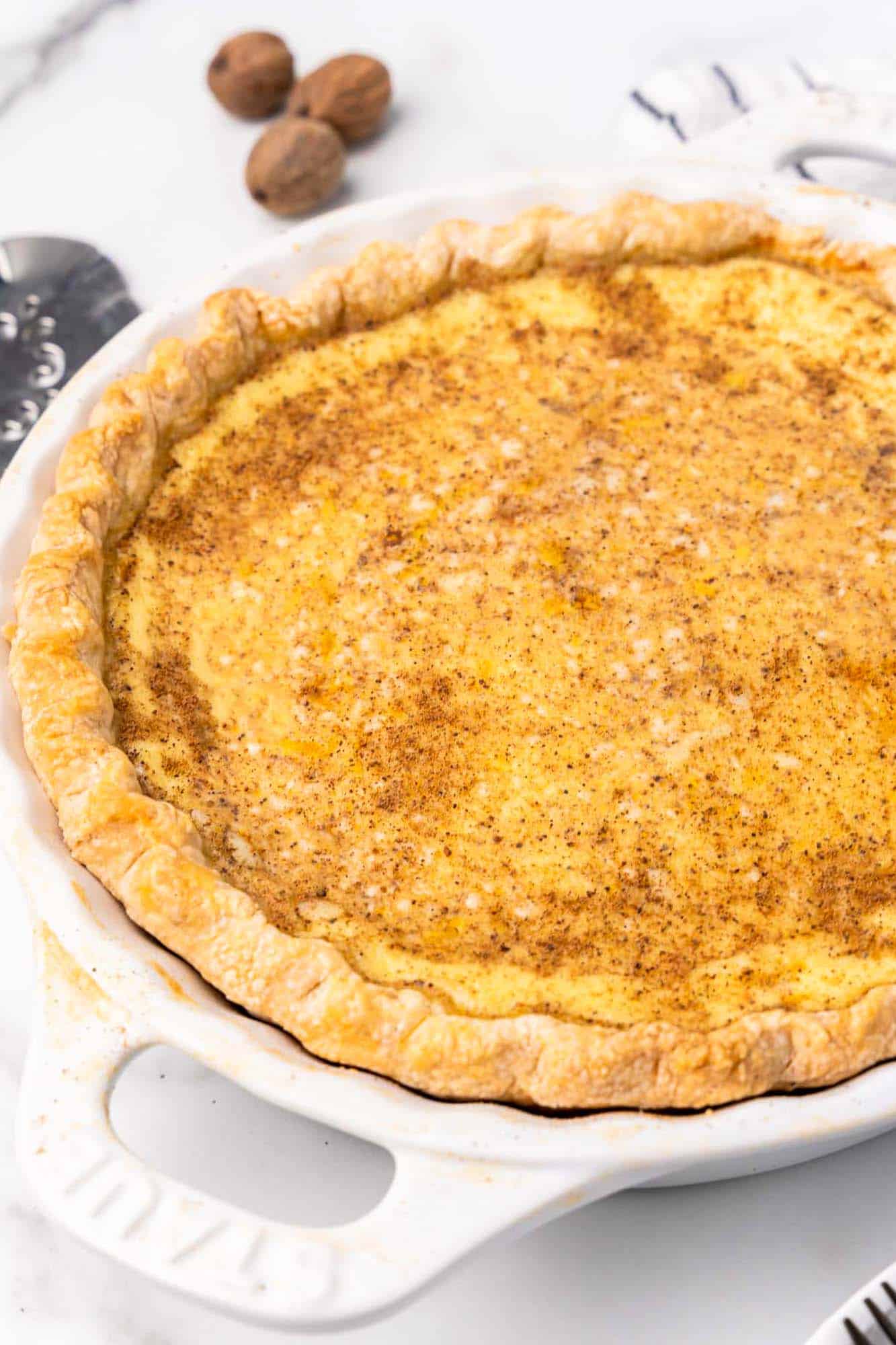 a custard pie in a white pie plate with handles