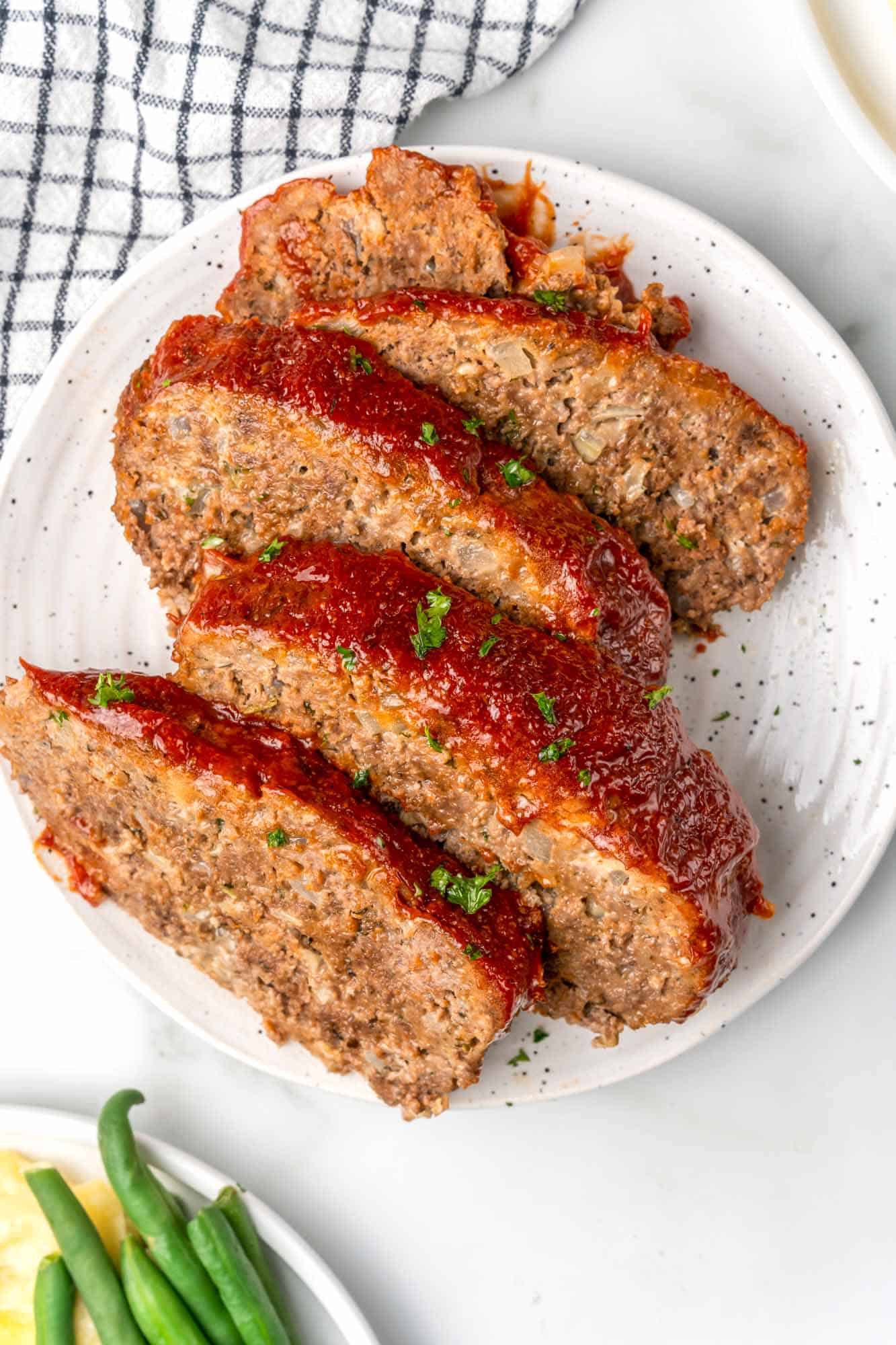 Slices of meatloaf on a white plate.