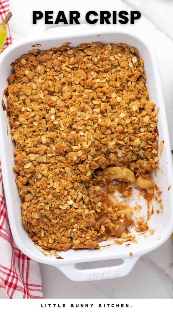 a white baking dish filled with pear crisp. One serving has been removed. Text at top of image says "pear crisp"