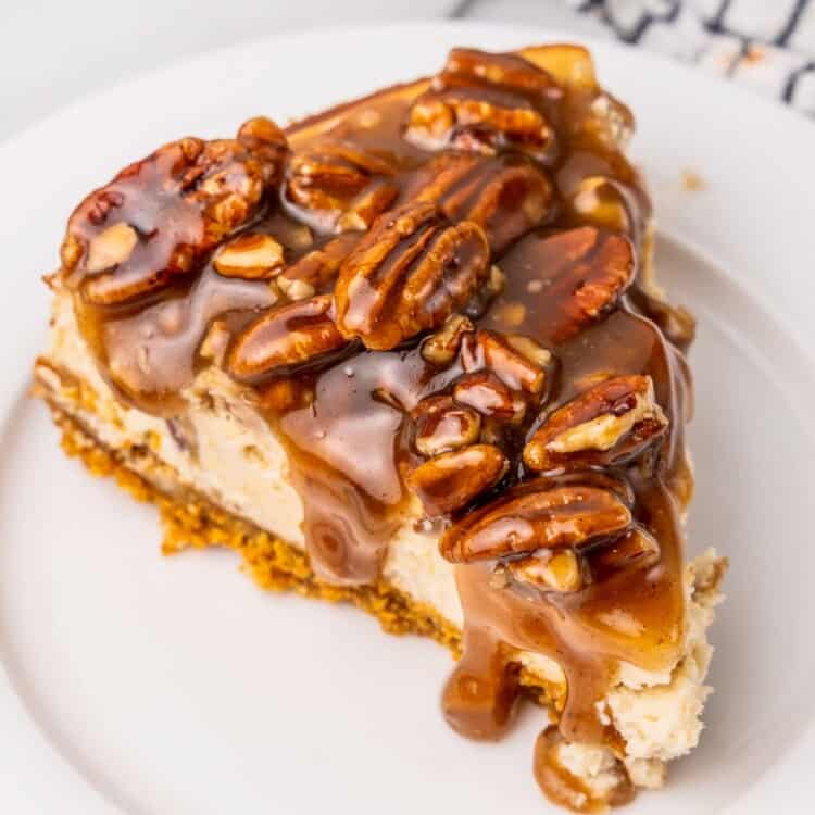 a slice of pecan pie cheesecake on a white plate