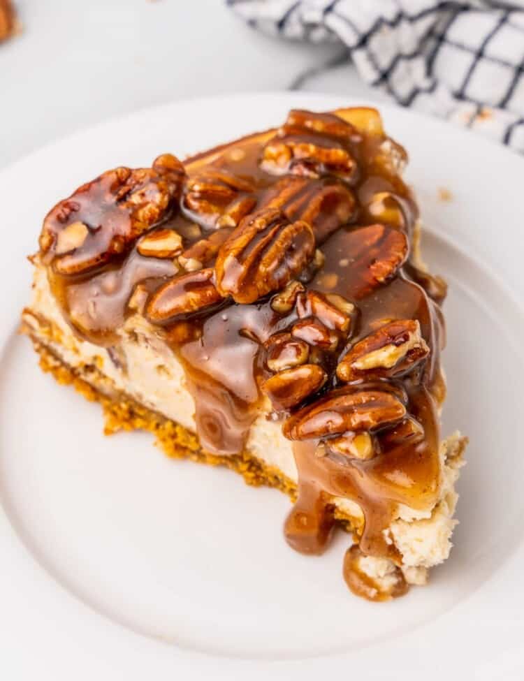 a slice of pecan pie cheesecake on a white plate
