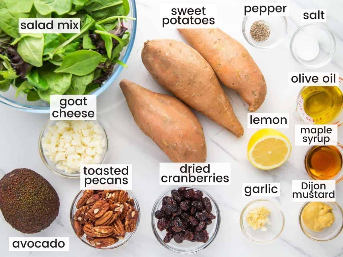 The ingredients needed to make a roasted sweet potato salad, including sweet potatoes and other salad ingredients, all in small bowls. 