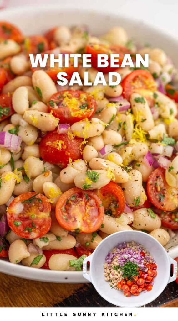 At an angle shot of white bean salad in a bowl, with cherry tomatoes, parsley, and lemon zest. With overlay text that says "white bean salad"