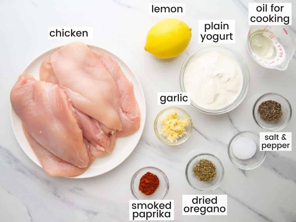 Ingredients needed to marinate chicken in yogurt with lemon juices, garlic, and spices.