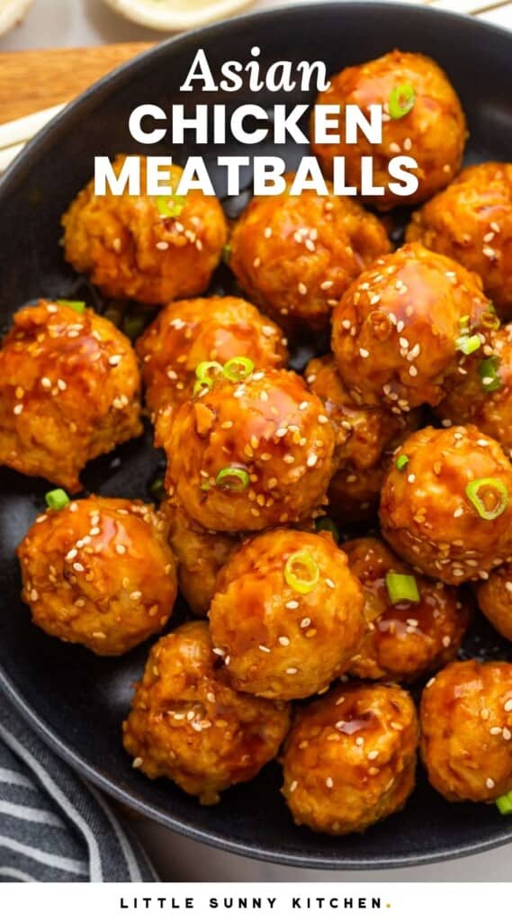 a bowl of chicken meatballs with asian sauce, sliced green onions and sesame seeds. text overlay says "asian chicken meatballs"