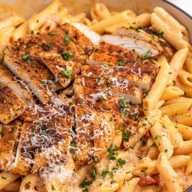 Creamy penne pasta topped with sliced cajun chicken