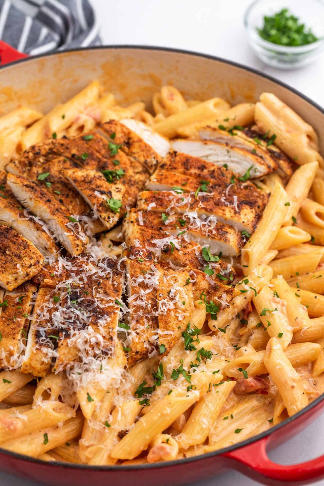 Creamy penne pasta topped with sliced cajun chicken 