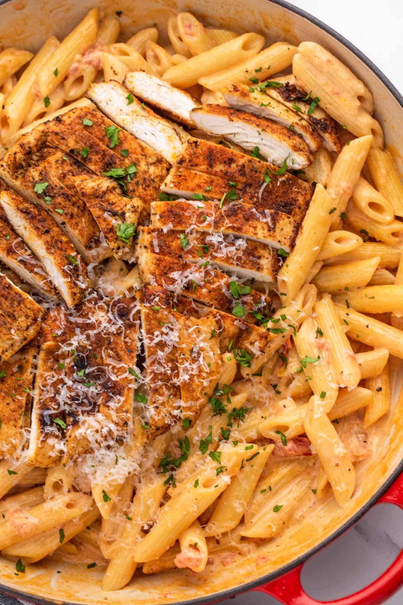 Creamy penne pasta topped with sliced cajun chicken