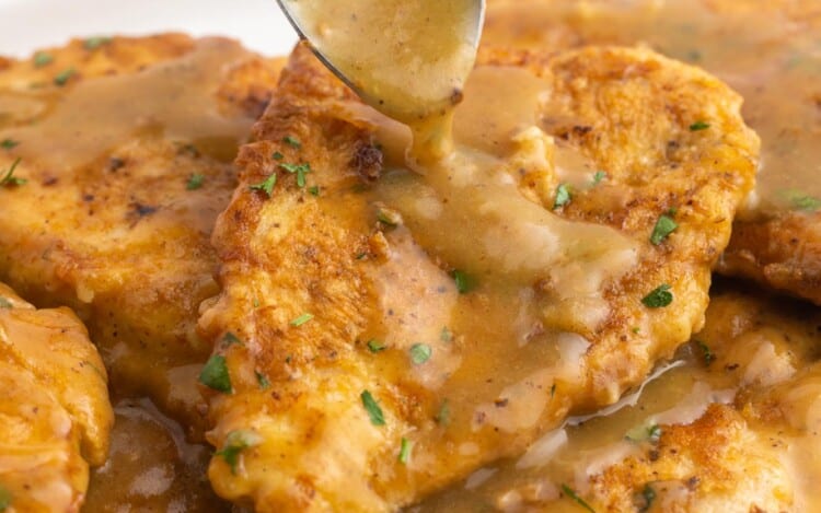 Drizzling sauce over chicken francese