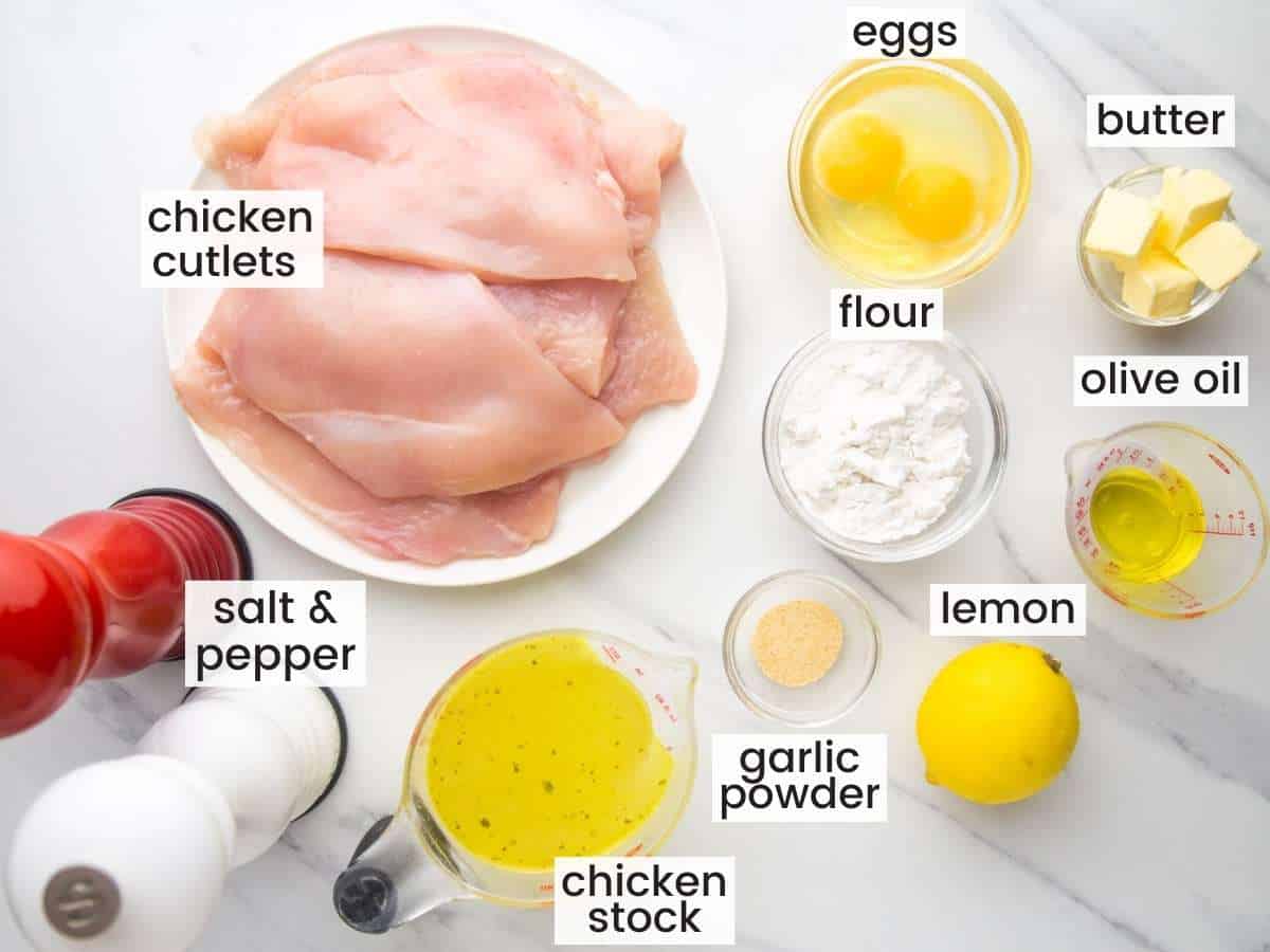 The ingredients needed to make chicken francese, all in small bowls, on the counter, viewed from above