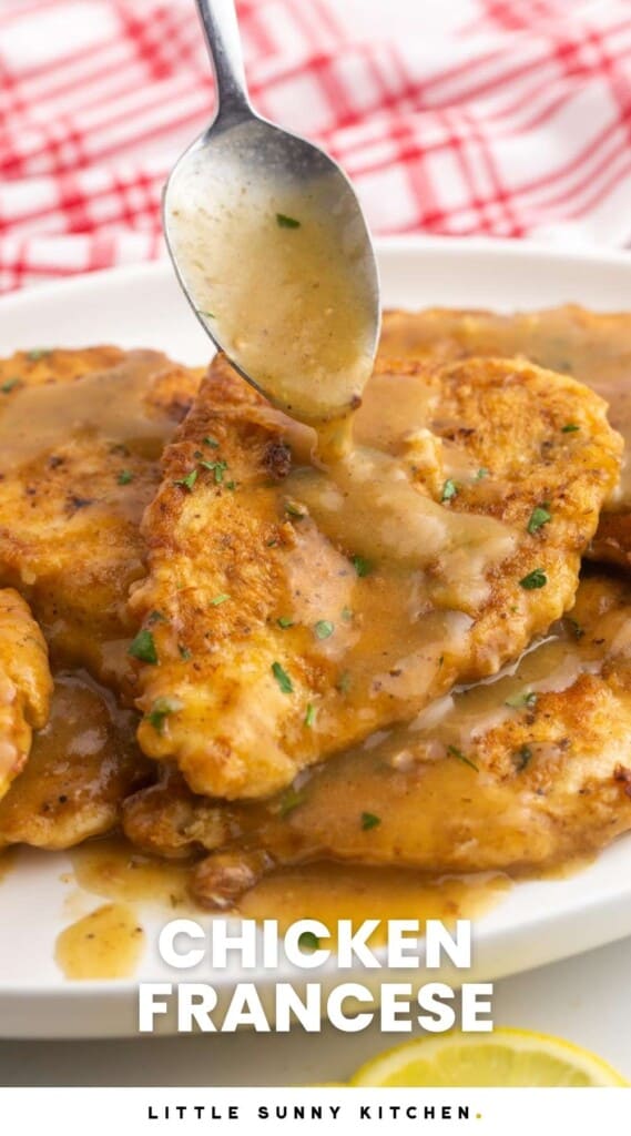 a spoon adding sauce to chicken francese