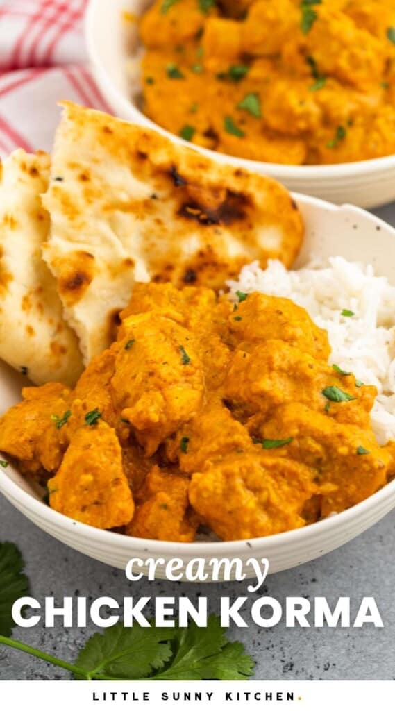 A bowl of chicken korma over rice with torn pita bread on the side. Text at bottom of image says "creamy chicken korma"