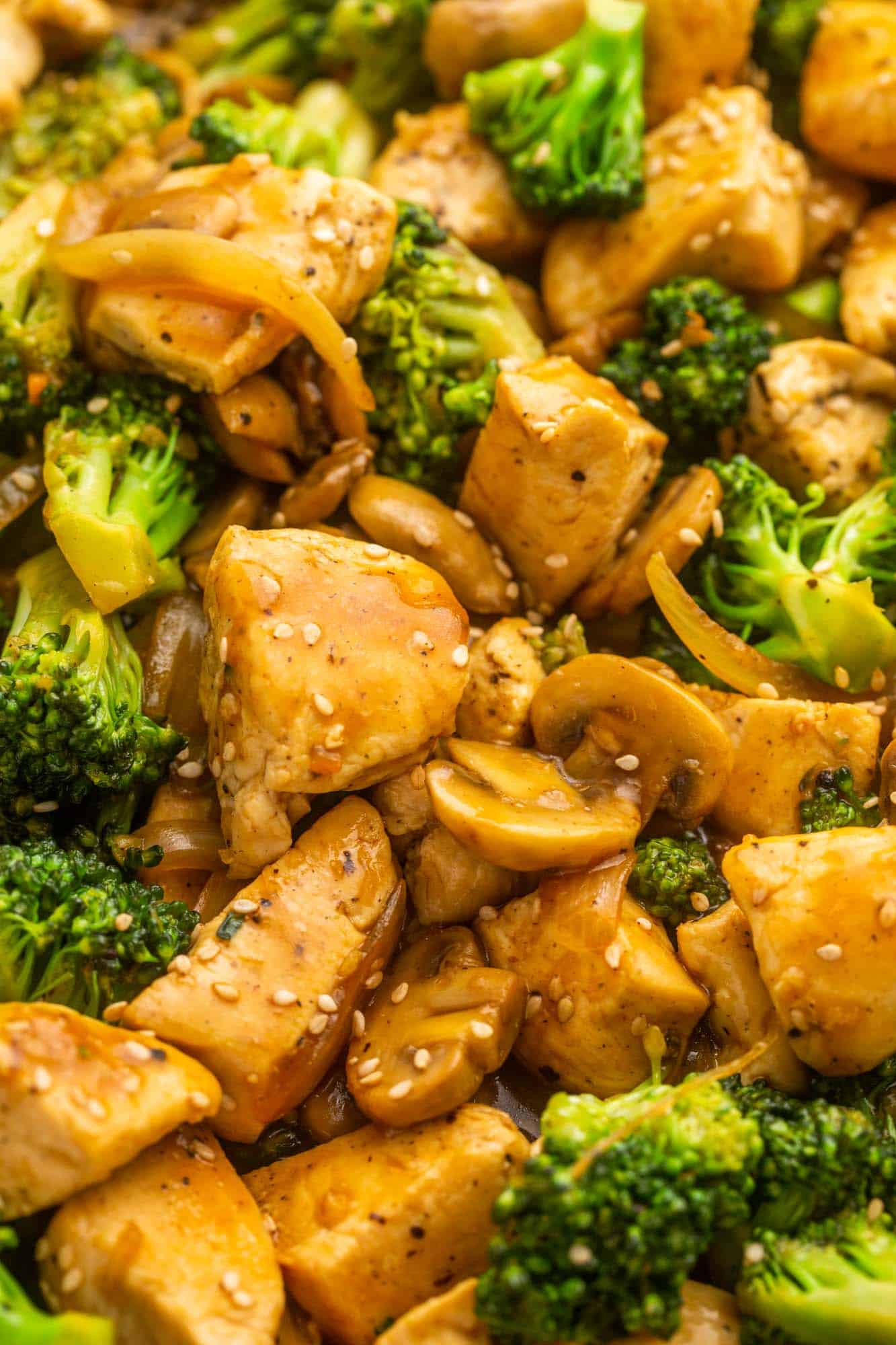 closeup shot of chicken and broccoli stir fry with mushrooms and onions