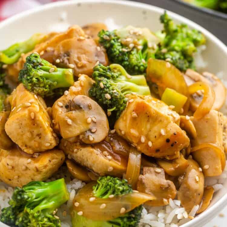 a bowl of rice topped with broccoli, chicken and mushroom stir fry
