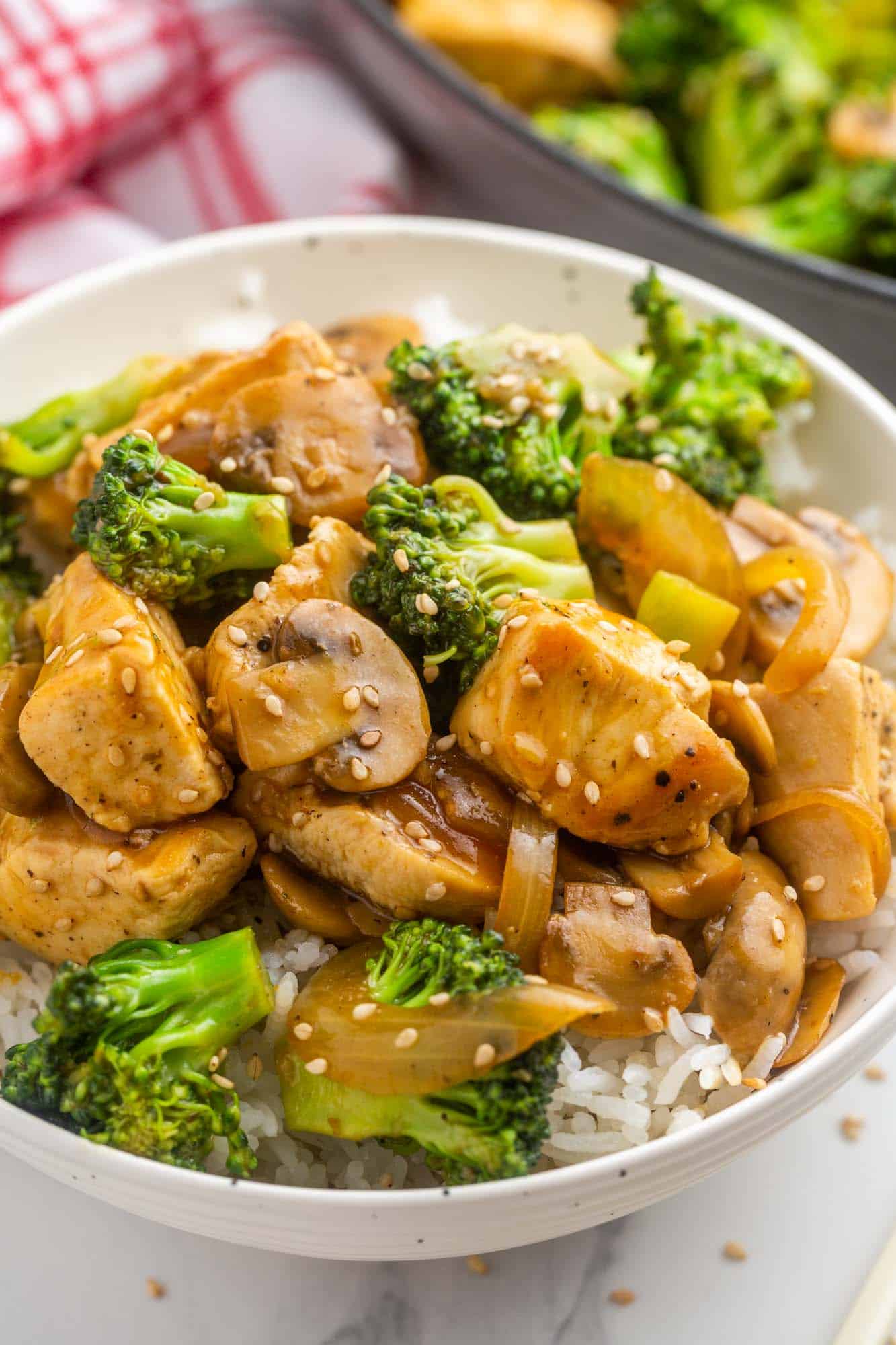 a bowl of rice topped with broccoli, chicken and mushroom stir fry