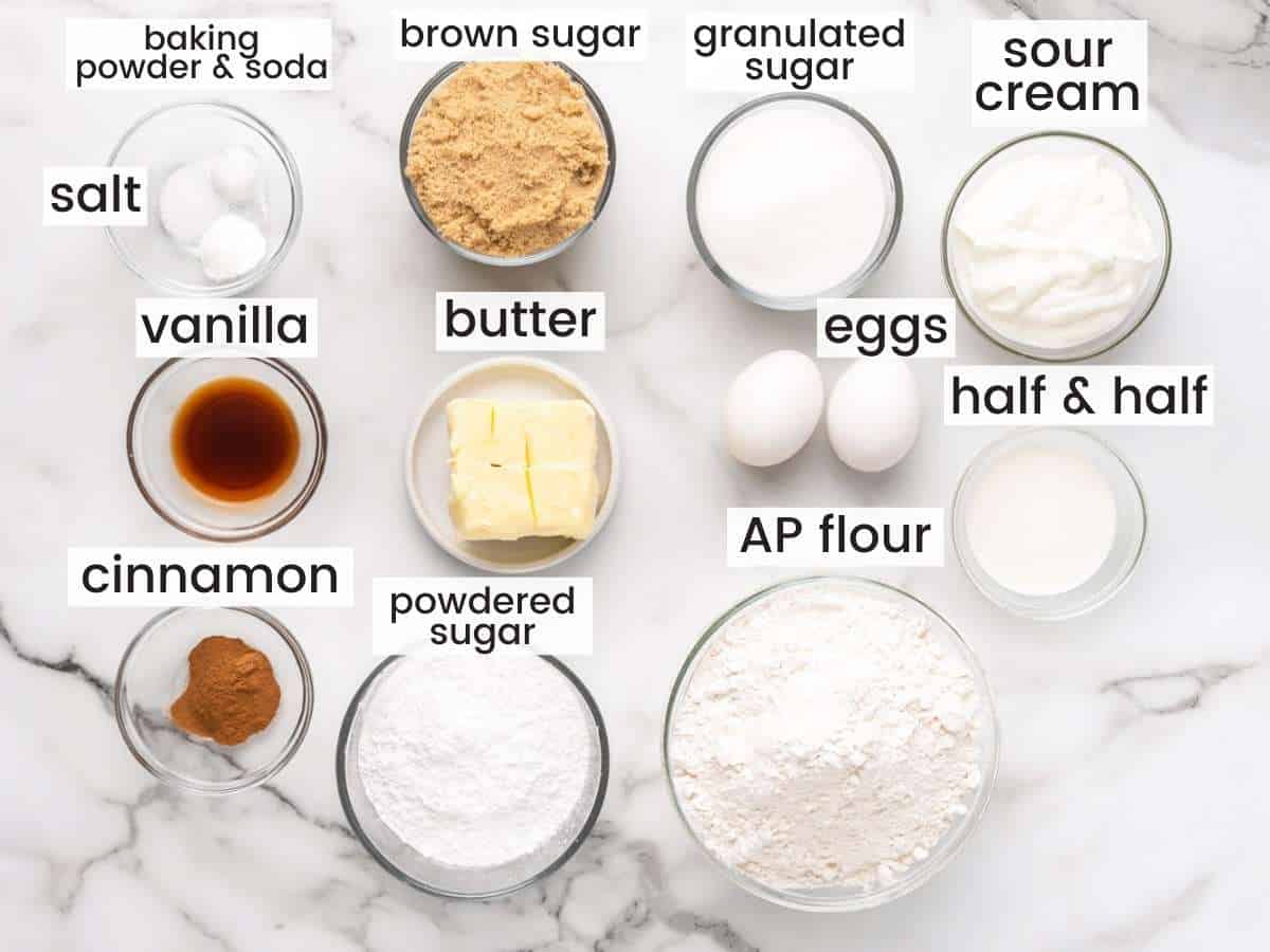 The ingredients in a recipe for cinnamon coffee cake, measured into small bowls, arranged on a counter.