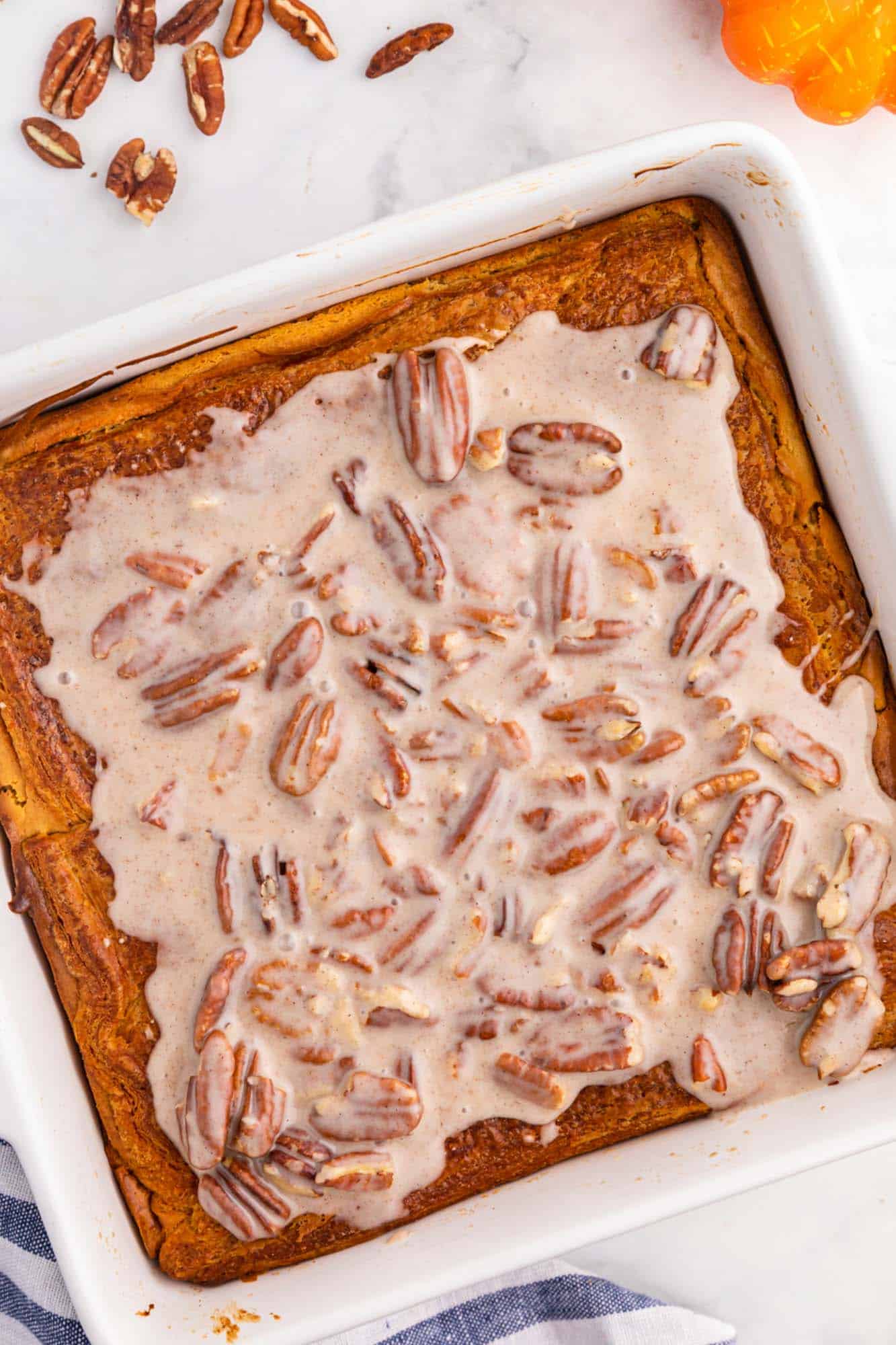 Overhead shot of the pumpkin cream cheese bars in a square pan with pecan icing on top